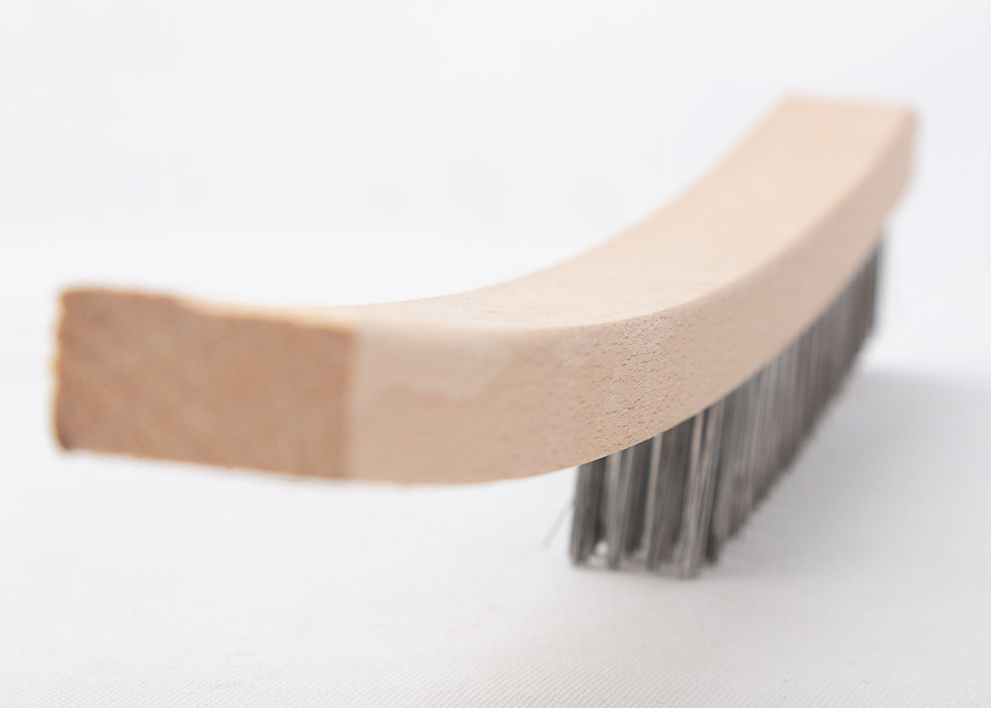 the curved wooden handle of our wire scratch brush