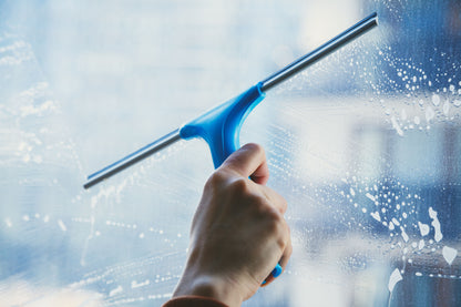 photo showing a squeegee being used to clean a window